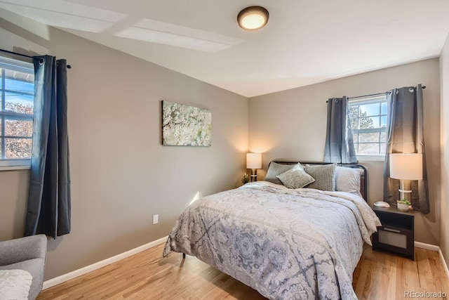 bedroom featuring light wood finished floors and baseboards