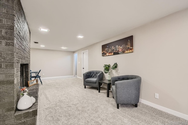 living area with baseboards, carpet, visible vents, and a brick fireplace