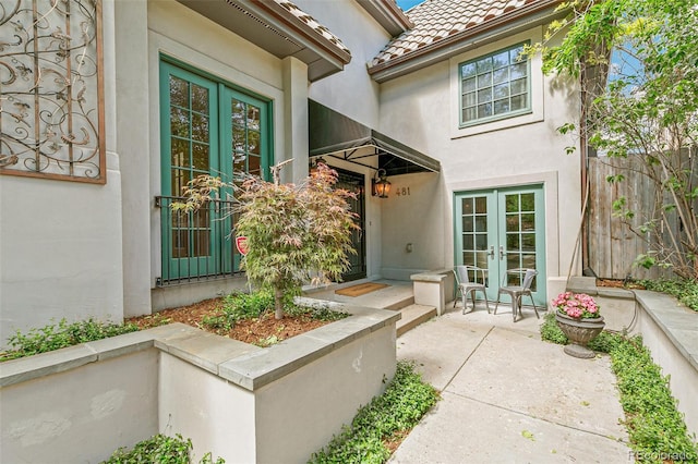 property entrance featuring a patio and french doors