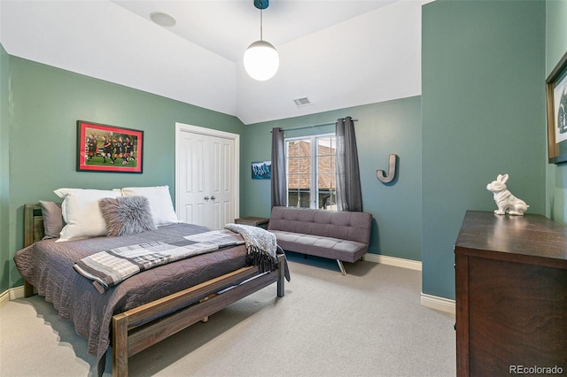 carpeted bedroom with vaulted ceiling and a closet