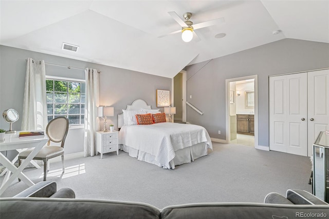 bedroom with lofted ceiling, light colored carpet, connected bathroom, and ceiling fan