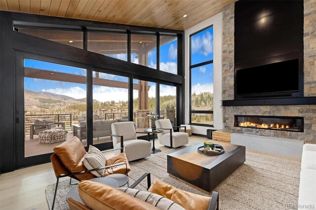 2800 Honors Ct, Silverthorne, CO 80498 - living room with expansive windows, a fireplace, a towering ceiling, wood finished floors, and a mountain view