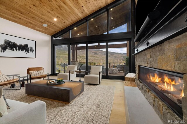 2800 Honors Ct, Silverthorne, CO 80498 - living area with a mountain view, a stone fireplace, wood finished floors, high vaulted ceiling, and wood ceiling