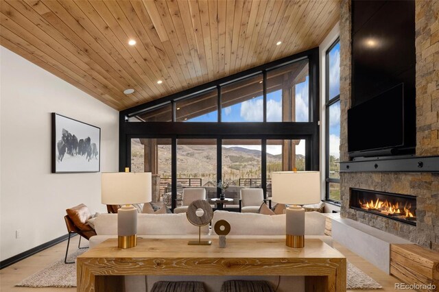 2800 Honors Ct, Silverthorne, CO 80498 - living area featuring expansive windows, plenty of natural light, a stone fireplace, wood finished floors, and wood ceiling