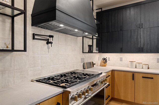 2800 Honors Ct, Silverthorne, CO 80498 - kitchen with stainless steel range, custom range hood, light countertops, backsplash, and dark cabinetry