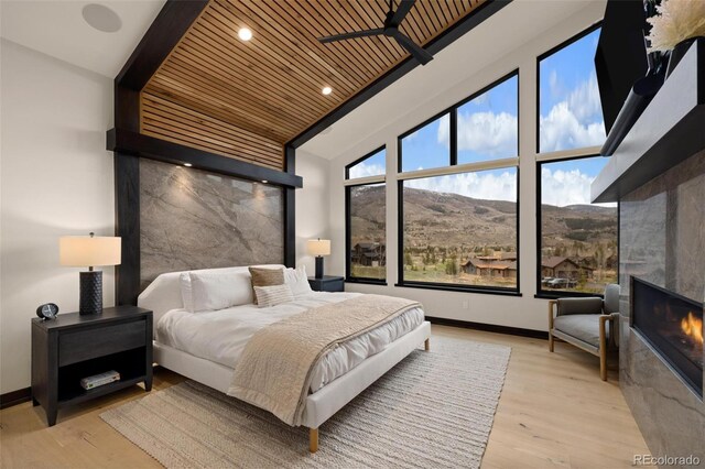 2800 Honors Ct, Silverthorne, CO 80498 - bedroom featuring wooden ceiling, wood finished floors, a glass covered fireplace, recessed lighting, and baseboards