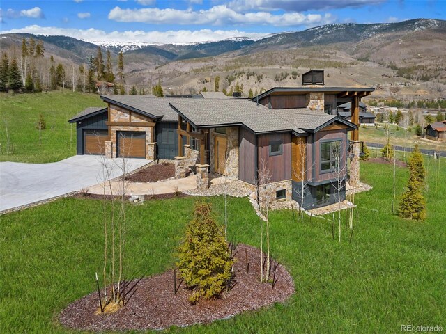 2800 Honors Ct, Silverthorne, CO 80498 - modern home with stone siding, a mountain view, a front yard, concrete driveway, and a chimney