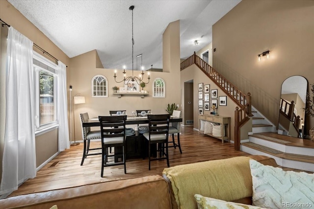 8051 W 78th Cir, Arvada, CO 80005 - dining area featuring stairway, a chandelier, wood finished floors, and vaulted ceiling