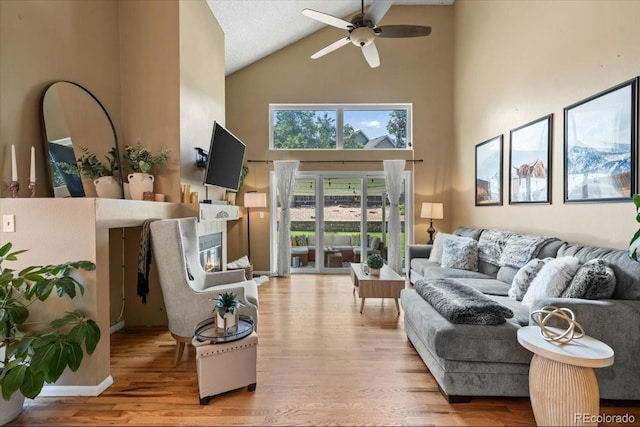 8051 W 78th Cir, Arvada, CO 80005 - living room featuring high vaulted ceiling, ceiling fan, light wood-style flooring, and a glass covered fireplace