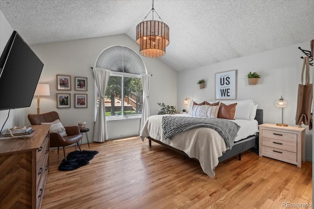 8051 W 78th Cir, Arvada, CO 80005 - bedroom featuring lofted ceiling, a chandelier, a textured ceiling, and light wood-type flooring