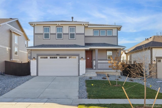 view of front of house with covered porch, a garage, and a front yard