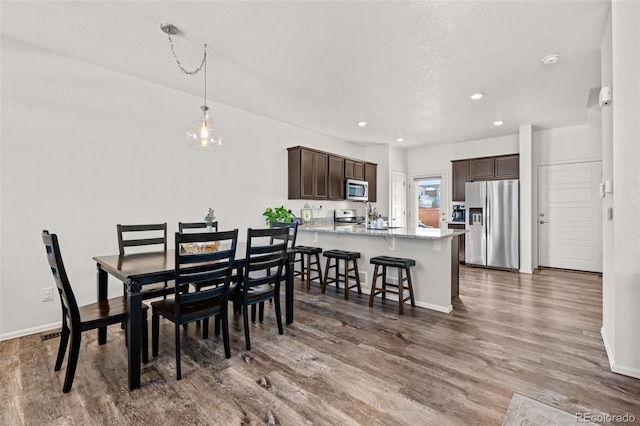 dining area with hardwood / wood-style floors and a textured ceiling