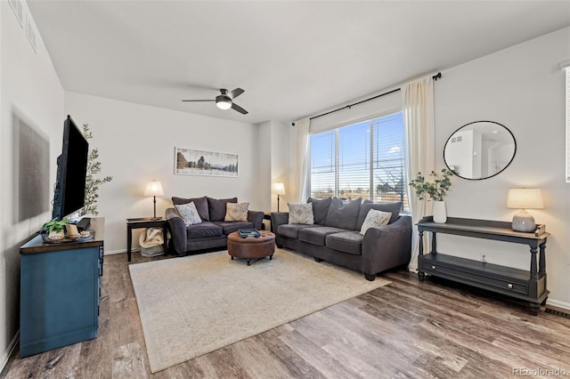 living room with dark wood-type flooring and ceiling fan