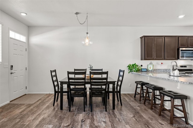 dining room with sink and dark wood-type flooring