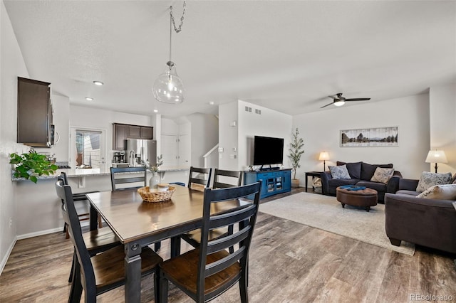 dining room with a textured ceiling, ceiling fan, and light hardwood / wood-style flooring