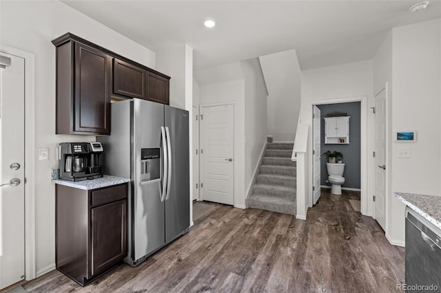 kitchen with dark hardwood / wood-style flooring, dark brown cabinets, light stone counters, and stainless steel fridge with ice dispenser