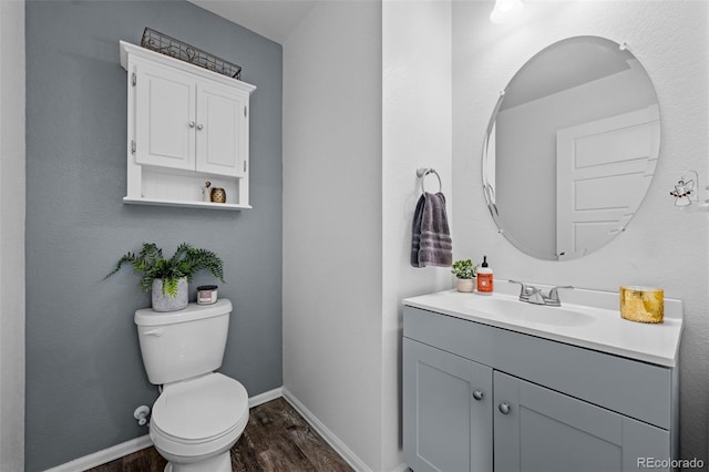 bathroom with vanity, toilet, and hardwood / wood-style floors