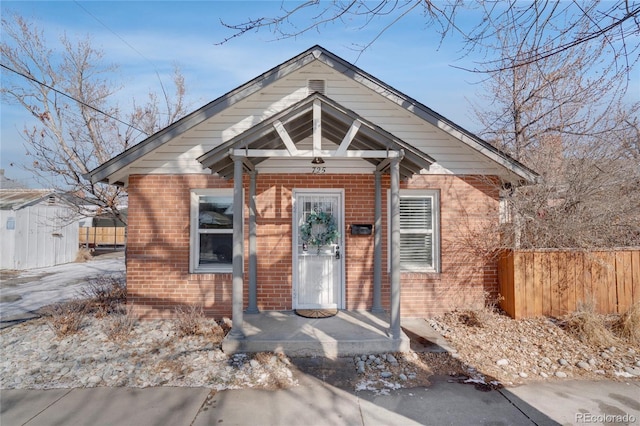 bungalow with fence and brick siding