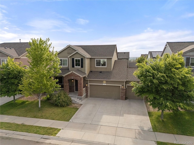 41 Jordan Ln, Erie, CO 80516 - view of front of property with brick siding, an attached garage, concrete driveway, a front lawn, and roof with shingles