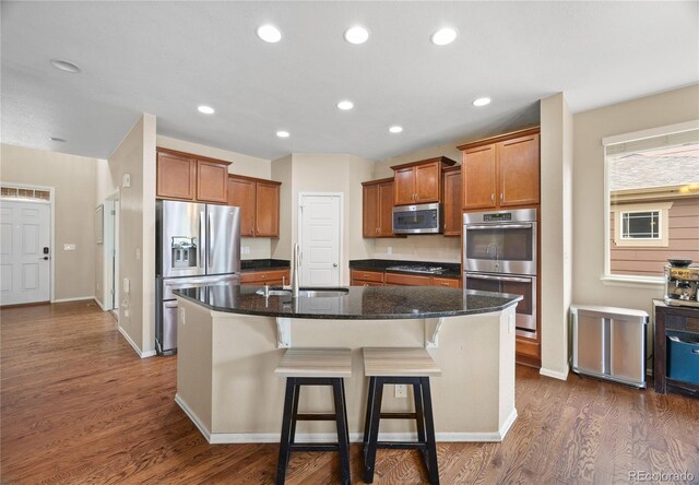 41 Jordan Ln, Erie, CO 80516 - kitchen featuring appliances with stainless steel finishes, a sink, dark wood finished floors, an island with sink, and recessed lighting