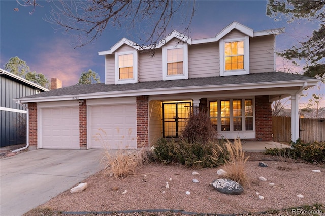 traditional home with driveway, fence, covered porch, a garage, and brick siding