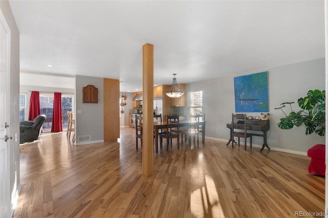 dining room featuring visible vents, baseboards, light wood-style floors, and a healthy amount of sunlight