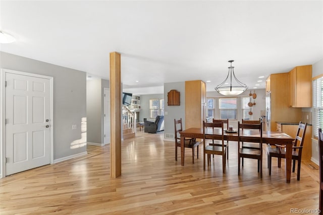 dining room featuring stairway, baseboards, and light wood-style flooring