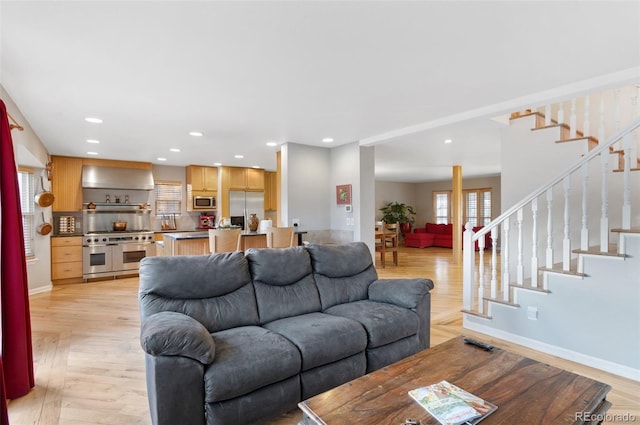 living area featuring stairway, recessed lighting, and light wood-style flooring