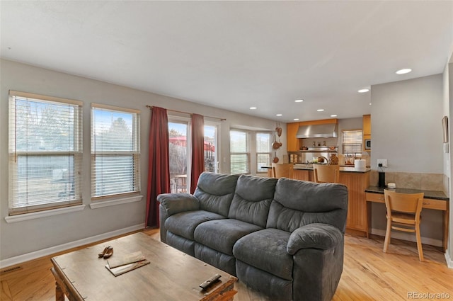 living room with recessed lighting, baseboards, and light wood-style floors