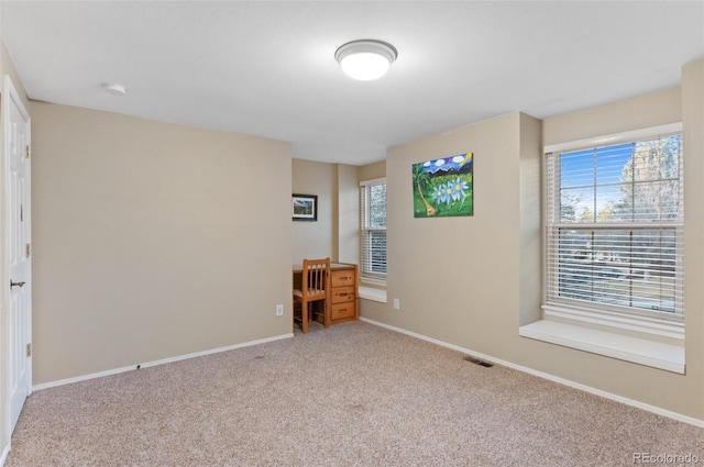 unfurnished bedroom with visible vents, carpet floors, and baseboards