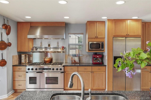 10200 Julian St, Westminster, CO 80031 - kitchen with dark stone counters, wall chimney exhaust hood, stainless steel appliances, and recessed lighting