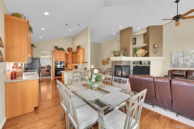 6696 S Quail Ct, Littleton, CO 80127 - dining room with a ceiling fan, light wood-style flooring, a glass covered fireplace, recessed lighting, and high vaulted ceiling