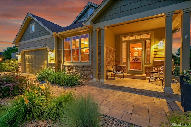 6696 S Quail Ct, Littleton, CO 80127 - property entrance featuring covered porch, stone siding, and a garage