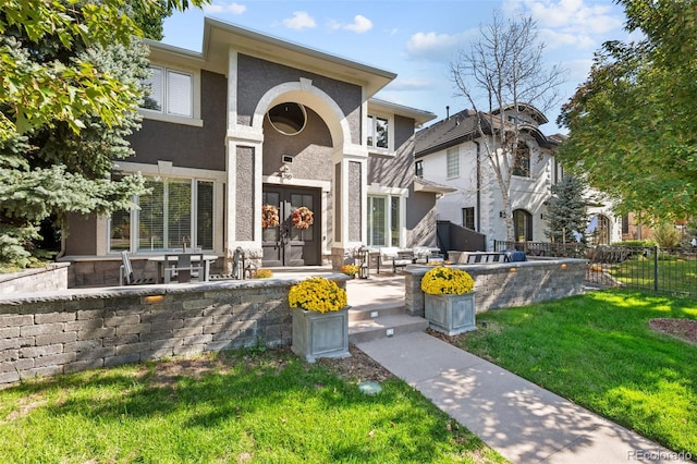 view of front of home with french doors and a front lawn