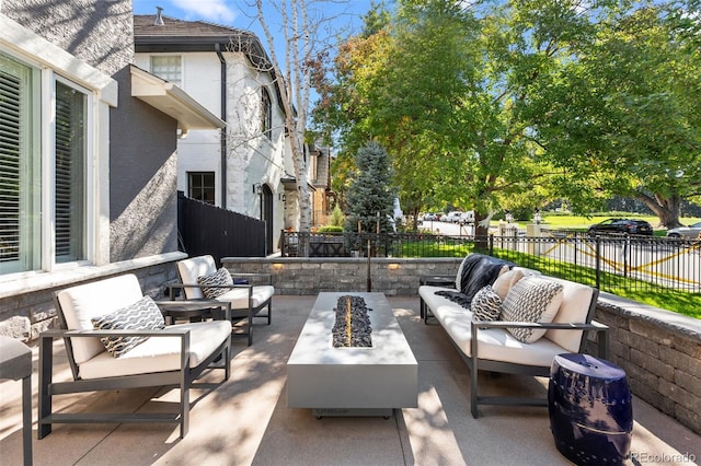 view of patio with an outdoor living space with a fire pit