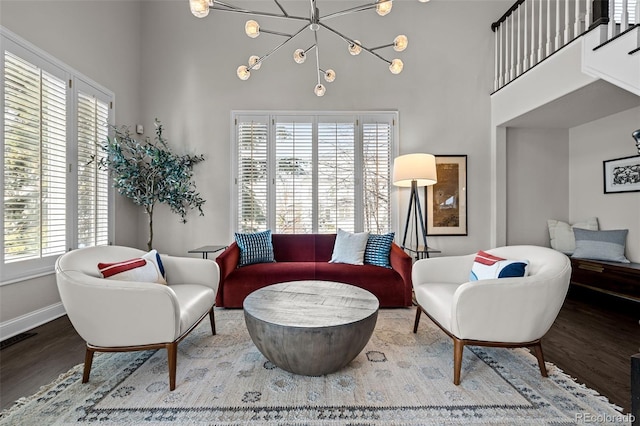 living room featuring a high ceiling, hardwood / wood-style flooring, a wealth of natural light, and a notable chandelier