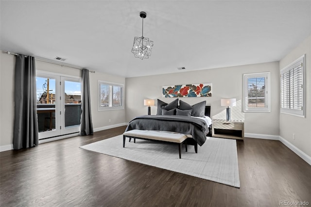 bedroom with access to outside, an inviting chandelier, multiple windows, and dark wood-type flooring