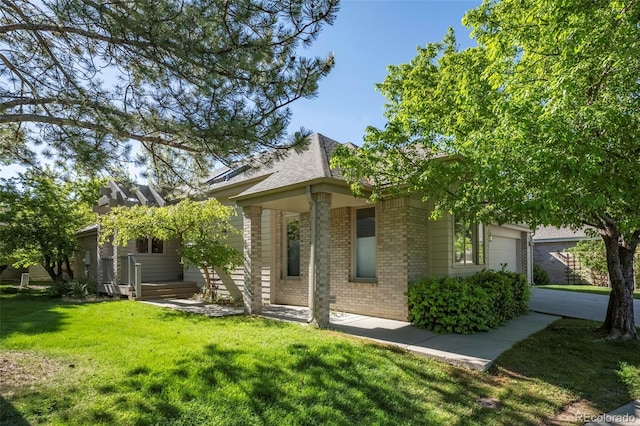 back of property with a garage and a lawn