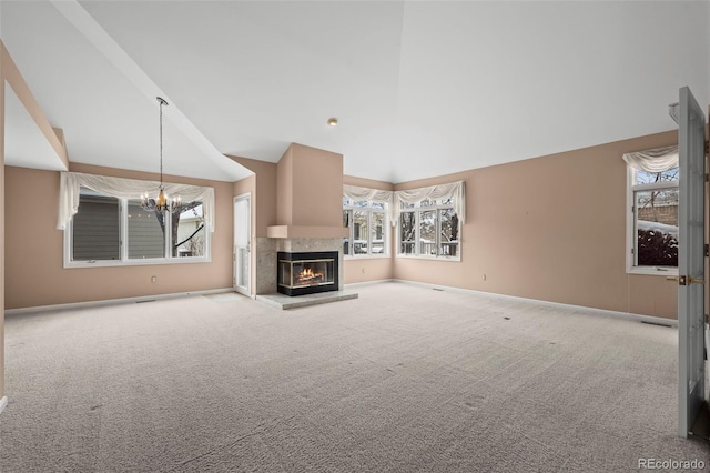 unfurnished living room with a multi sided fireplace, carpet flooring, a notable chandelier, and high vaulted ceiling