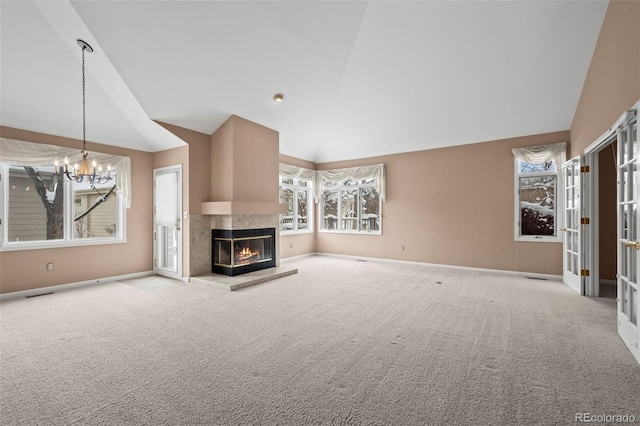 unfurnished living room with a multi sided fireplace, lofted ceiling, light carpet, and a notable chandelier