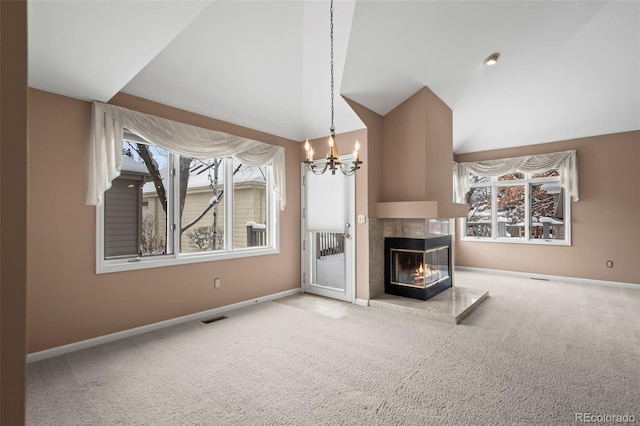 unfurnished living room featuring light carpet, lofted ceiling, a tile fireplace, and an inviting chandelier