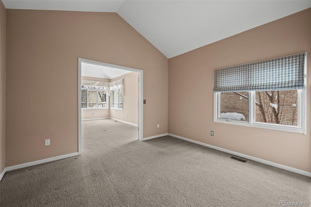 carpeted empty room featuring lofted ceiling