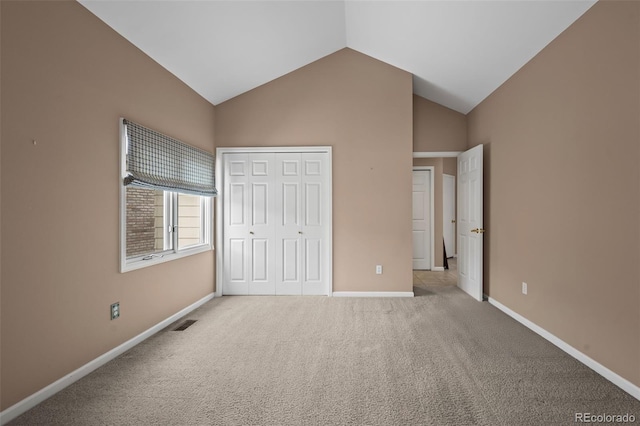 unfurnished bedroom featuring lofted ceiling, light colored carpet, and a closet