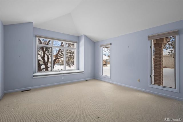 carpeted empty room with lofted ceiling