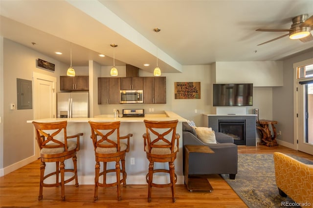 kitchen with light countertops, appliances with stainless steel finishes, a breakfast bar area, and ceiling fan