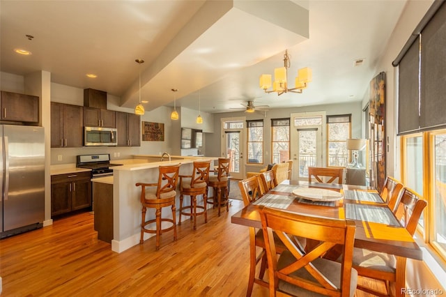 dining room featuring recessed lighting, ceiling fan with notable chandelier, and light wood finished floors