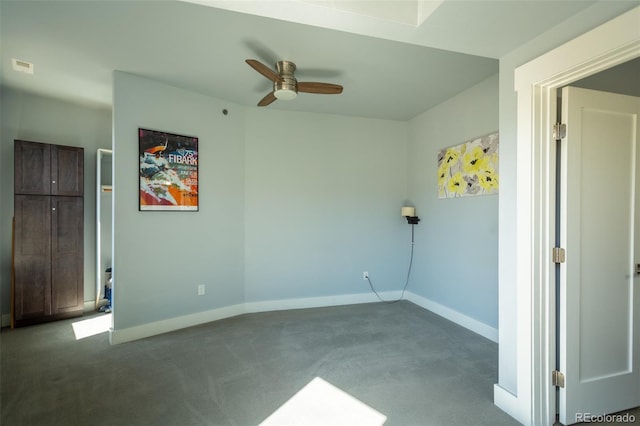 carpeted empty room with a ceiling fan, baseboards, and visible vents