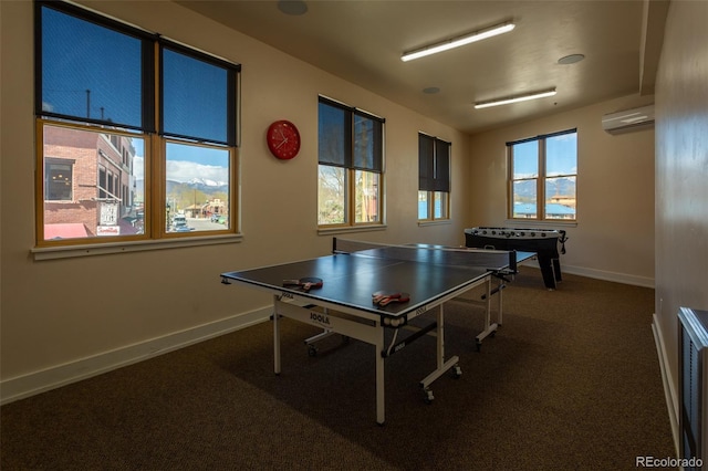 rec room featuring baseboards, carpet, and a wall unit AC