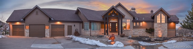 view of front of property featuring a garage, stone siding, a chimney, and driveway