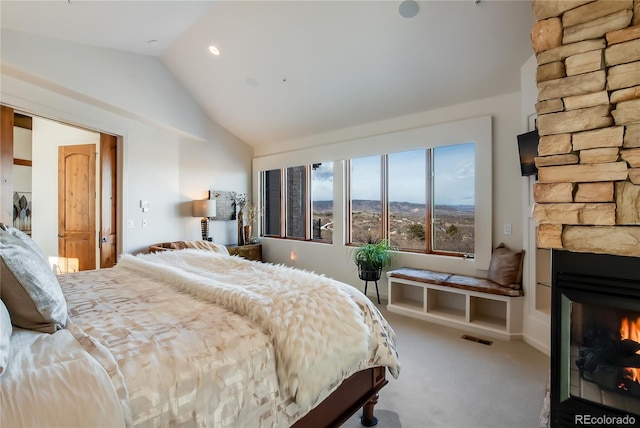 bedroom featuring lofted ceiling, a large fireplace, visible vents, and carpet floors